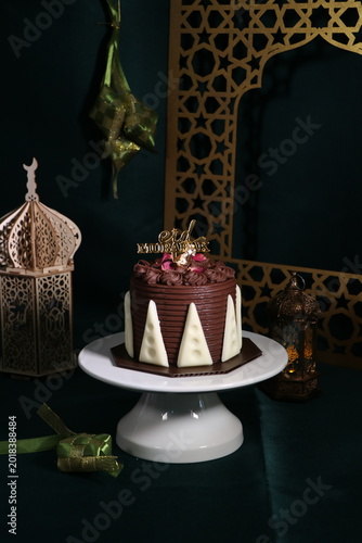 Chocolate cake (sponge, mousse, crunch, sauce) arranged artistically and separated on the plate, with Eid Mubarak topper.