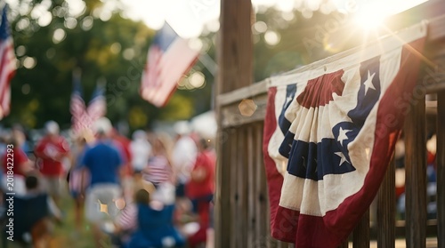 American flag bunting decoration on wooden fence with sun flare