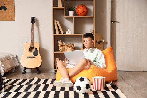 Teenage boy watching footba...