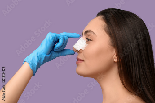 Woman with bandaged nose af...