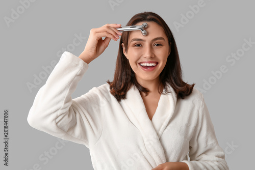 Young woman in bathrobe mas...
