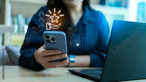 Loyalty rewards and redeem points concept with smartphone app. Close up of woman using mobile phone with glowing star icon for customer privilege, membership bonus, and marketing promotion program