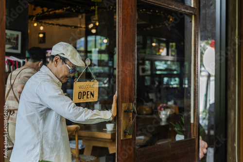 family small business coaching, senior cafe owner giving instruction to young son barista standing at storefront, learning by doing with new generation, leadership daily operation guidance concept.