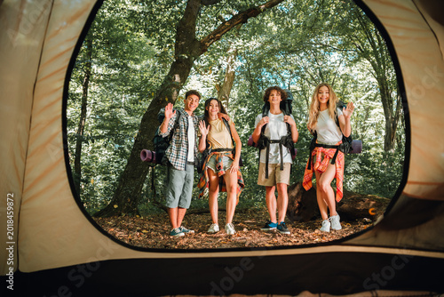 Fotografía Friends waving at tent opening during a sunny forest camping and backpacking tri