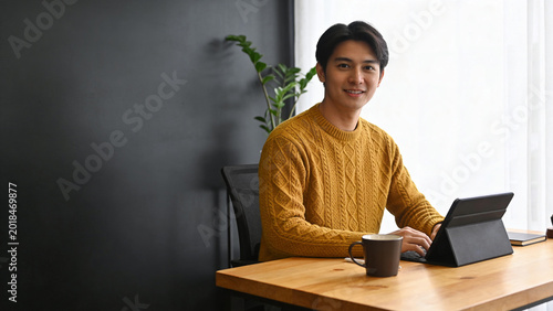 Young Asian Entrepreneur Working On Laptop In Modern Cafe