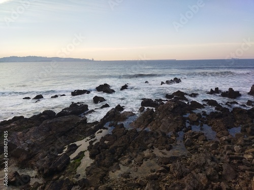 Costa rocosa al atardecer con vistas a la bahía