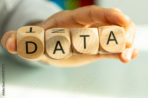 Conceptual image of wooden blocks spelling DATA held by hand.
