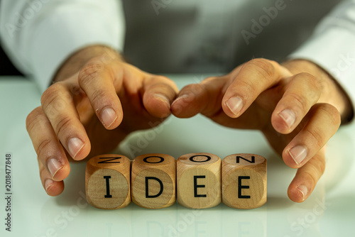 Hands shielding wooden cube...