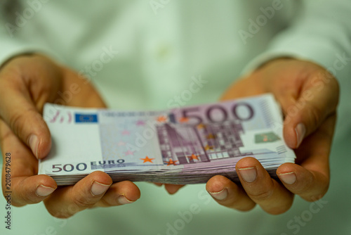 Konstfotografi Close-up of hands holding a thick wad of 500 euro bills, conveying wealth and financial concepts