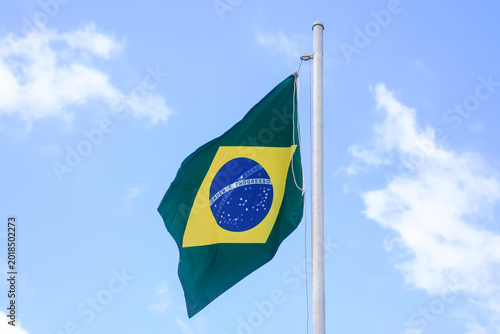 Vibrant Brazilian Flag Waving Outdoors Under a Clear Blue Summer Sky Background