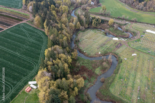 Aerial drone view of winding river flowing through farmland in Oregon USA scenic Pacific Northwest landscape with agricultural fields and natural environment
