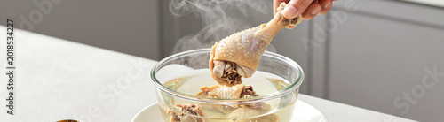 shot person lifting steaming hot boiled chicken drumsticks transparent broth placing onto waiting plate