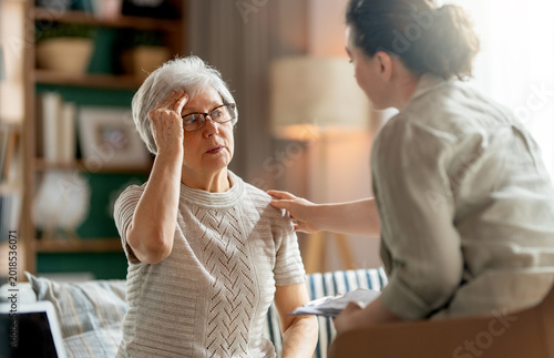 Obraz na płótnie Concerned Senior Woman Being Comforted by Caregiver at Home
