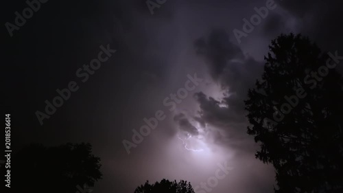 Lightning strikes on a dark night sky over a city landscape, captured in slow motion.