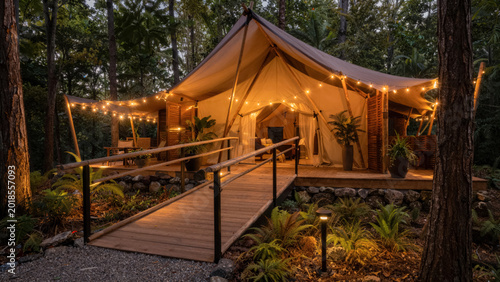 Modern eco friendly glamping tent with wooden ramp for wheelchair access in pine forest sustainable tourism