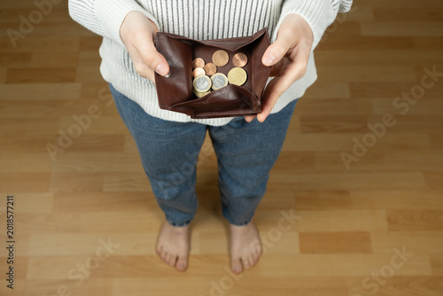 Fotografie Barefoot person holding a coin pouch, modest income or financial carefulness