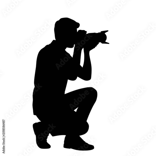 Bild auf Leinwand Professional photographer silhouette crouching and taking photo with digital dsl