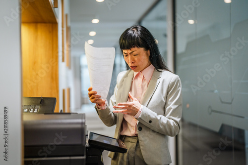 Valokuva Businesswoman frustrated with office printer technology failure