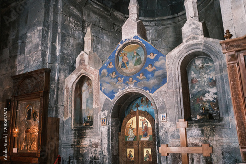 Interior view of the ancient Gergeti Trinity Church in Kazbegi, Georgia. Detail of the medieval stone altar, religious frescoes, and orthodox icons inside the 14th-century mountain monastery 