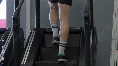 Climbing stairs in a gym during evening workout session focusing on leg exercise for fitness