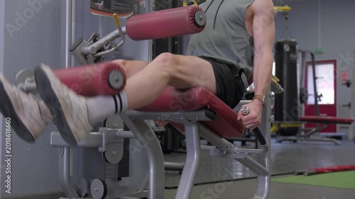 Man using leg extension machine in gym for workout at fitness center