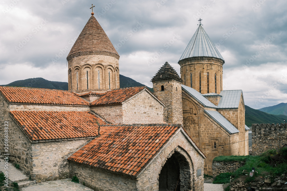 Fototapeta premium Detailed view of the medieval stone towers and tiled roofs of the Ananuri Fortress complex in Georgia. Historic 17th-century orthodox architecture overlooking the Aragvi River valley