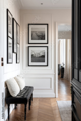 Elegant Hallway Interior with Black Tufted Bench, Classic Wall Molding and Gallery Wall of Framed Art Prints
