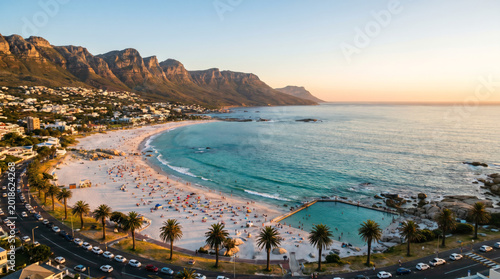 Aerial view of Camps Bay beach in Cape Town, South Africa, with Lion's Head mountain in the background at sunset.