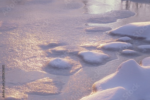 Bild auf Leinwand Serene frozen water and snowdrifts bathed in magical winter sunlight