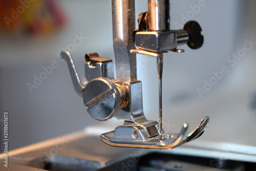 Konstfotografi Sewing machine presser foot and needle holder assembly on a metal needle plate
