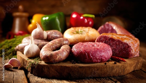Assortment of Raw Meats and Vegetables on a Wooden Board.