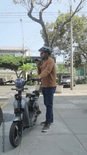 Man with Helmet Sending Voice Message on Electric Bike