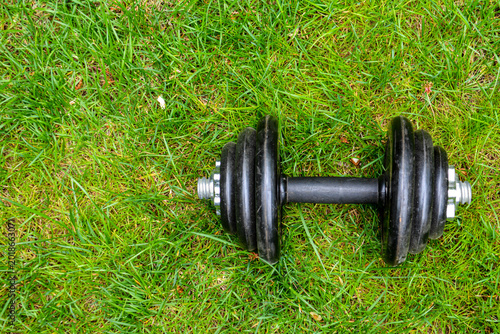 Dumbbells on green grass background. Fitness and healthy lifestyle concept. Fitness equipment on the grass. Bodybuilding