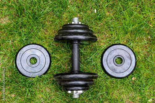 Dumbbells on green grass background. Fitness and healthy lifestyle concept. Fitness equipment on the grass. Bodybuilding