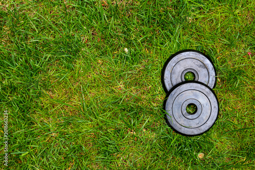 Dumbbells on green grass background. Fitness and healthy lifestyle concept. Fitness equipment on the grass. Bodybuilding