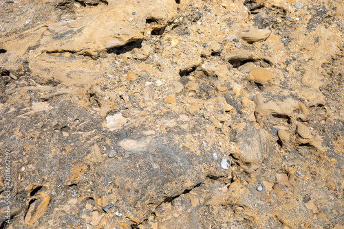 Schilderij op canvas Close-up view of a rocky surface displaying various textures, including sandy an