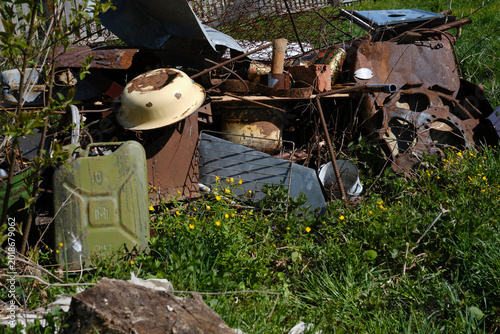 Foto Old green jerry can and scrap metal in the backyard of a rural house