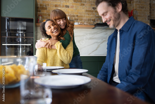 Friends hugging during a celebratory meal together