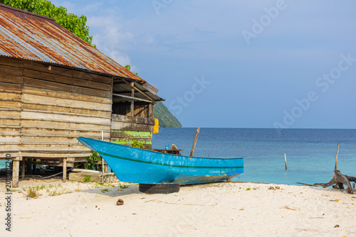 Tableau sur toile The beach scene with boat under palm tree