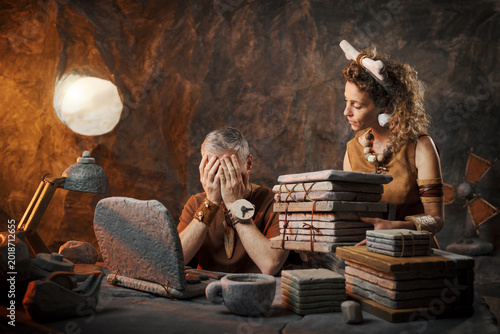 Tableau sur toile Overworked Caveman Stressed at Desk – Prehistoric Office Burnout and Heavy Workl