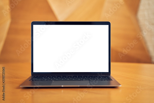 Laptop with blank white screen on wooden desk