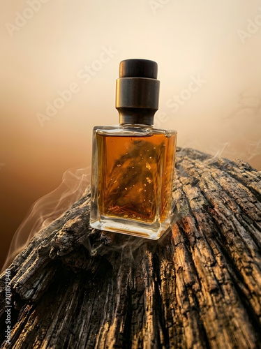 Elegant perfume bottle on textured wood against a warm hazy backdrop
