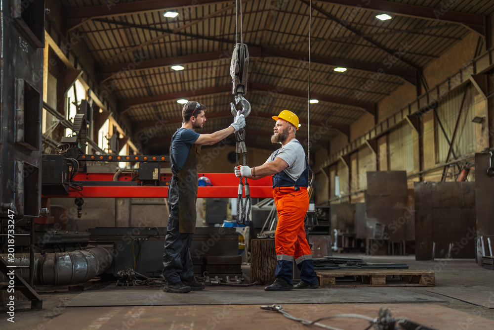 Fototapeta premium Industrial workers preparing heavy crane hook for lifting