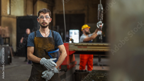 Bild auf Leinwand Metalworker in safety gear standing in industrial factory