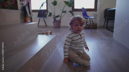Картината върху платно Toddler sliding off wooden step onto floor creating playful moment of movement c