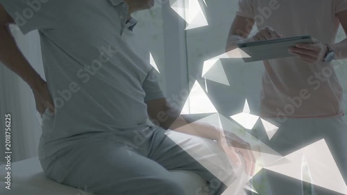 Senior patient showing back pain in exam while doctor tapping tablet causing shards covering torso