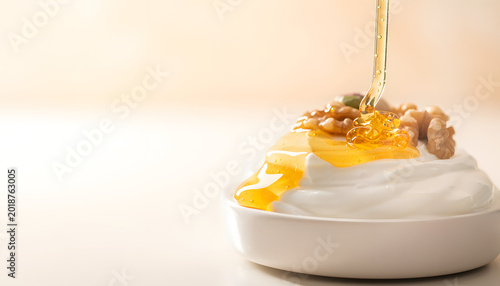Pouring Honey Over Greek Yogurt with Nuts Close Up