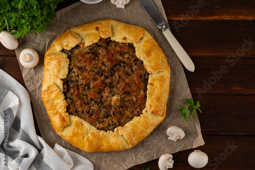Tableau sur toile Savory galette or open pie with mushroom, onion and cheese on a dark wooden background