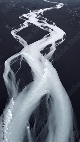 Aerial View Of Abstract Glacial River Network Flowing Through Black Volcanic Sand In Iceland