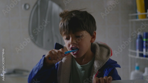Bild auf Leinwand Young boy brushing teeth in bathroom before school creating calm morning moment